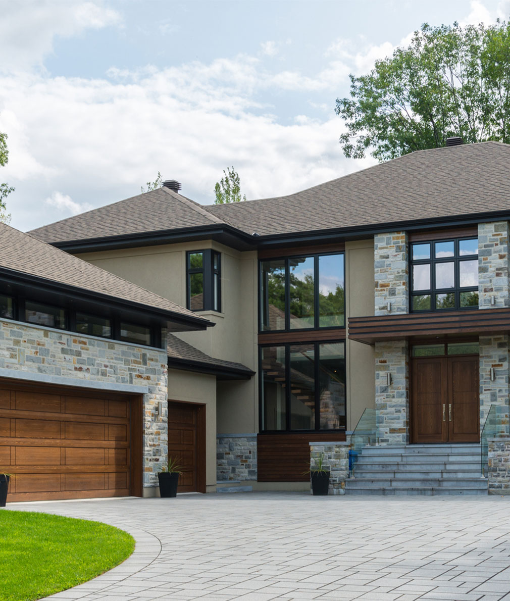 Elegant home with stone accents and concrete paver driveway